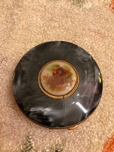 a black and gold plate sitting on top of a carpet