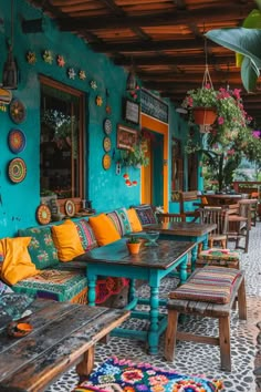 an outdoor seating area with wooden tables and colorful rugs