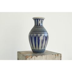 a blue and white vase sitting on top of a wooden block