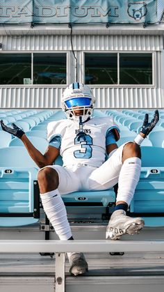 a football player sitting on the bleachers with his feet up in the air