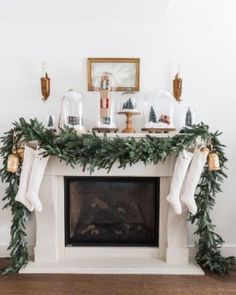 a fireplace decorated for christmas with stockings and candles