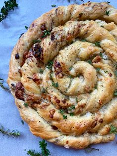 a close up of a pastry on a table with green sprigs around it