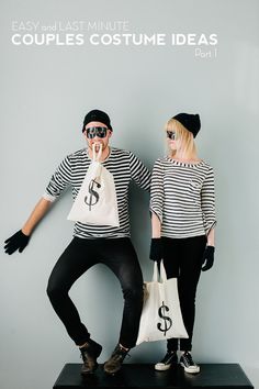 two people standing next to each other with bags in front of their faces and one holding a dollar sign