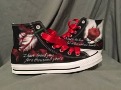 a pair of black and white shoes with red bows on them, decorated with flowers