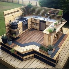 an outdoor kitchen made out of pallets and wooden planks, with potted plants on the deck