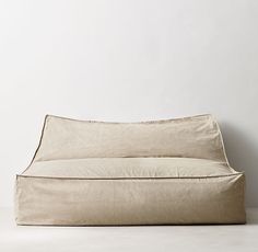 a beige couch sitting on top of a white floor