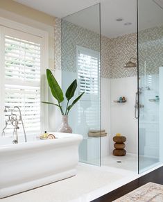 a white bath tub sitting next to a walk in shower