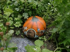 an orange ball sitting in the middle of some plants