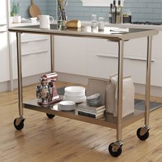 a kitchen cart with plates, bowls and cups on it in the middle of a wooden floor