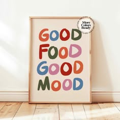 a framed poster with the words good food is good mood in multicolored letters