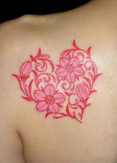 a heart shaped tattoo with pink flowers on it