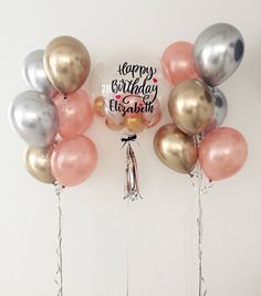 a bunch of balloons that are in the shape of a happy birthday sign and some tassels