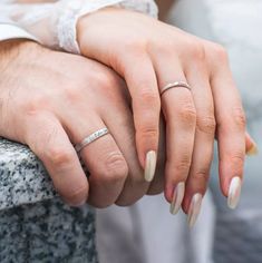 two people holding hands with wedding rings on their fingers