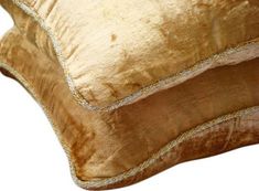 a gold colored pillow on a white background with no image to provide a caption for