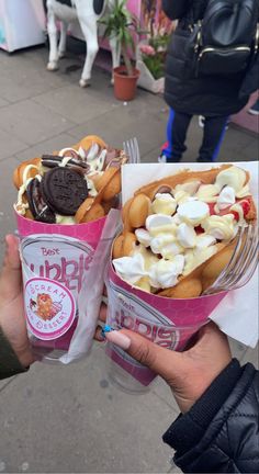 two people holding ice cream and cookies in their hands