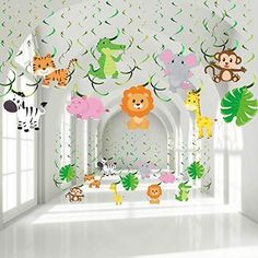 a room filled with lots of animals hanging from the ceiling next to a white wall