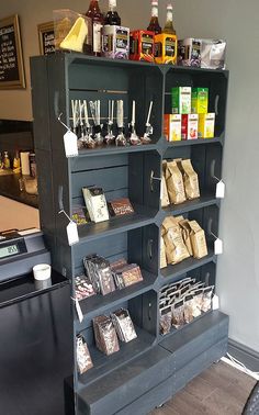 a display case filled with lots of different types of drinks on top of a wooden table