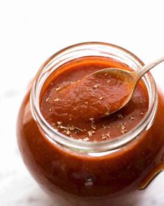 a spoon in a jar filled with sauce