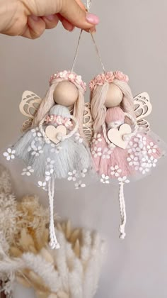 two little angel ornaments hanging from a string