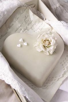 a white heart shaped cake sitting on top of a table