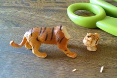 two toy animals on a wooden table with scissors