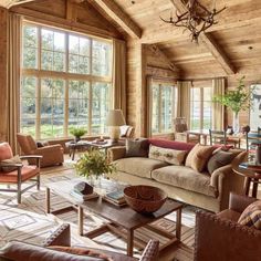 a living room filled with lots of furniture and large windows covered in wood planks