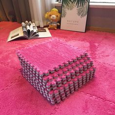 a pile of pink lego blocks sitting on top of a pink rug next to a window