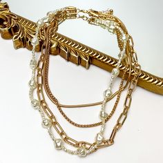 Four Strand Gold Tone Chain Necklace With Pearl Strand. Pictured on a white background with part of the necklace laying on a mirror with a gold trim. Necklace With Pearl, Giddy Up Glamour, Pearl Strand, Look Beautiful, Pearl Strands, Strand Necklace, Special Occasion, Chain Necklace, Gold Tones