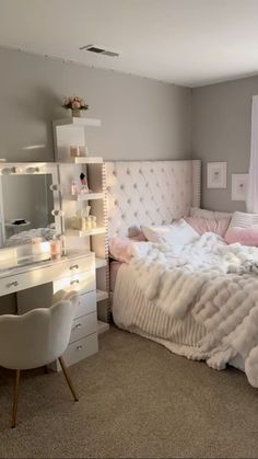 a bedroom with a white bed, desk and chair in it's center area