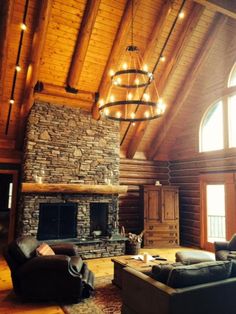 a living room filled with furniture and a fire place under a large chandelier