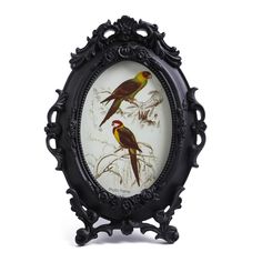 two birds sitting on top of a tree branch next to a framed photo in an ornate frame