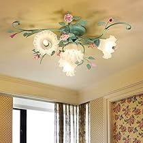 the ceiling light is decorated with flowers and leaves