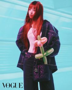 a woman with long red hair holding a flower