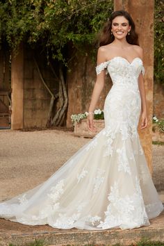 a woman in a wedding dress posing for the camera