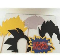 some paper cut outs with different shapes and colors are on a white surface, one has the word kalehananaha written in red