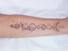 an arm tattoo with the solar system on it and eight planets in black ink,