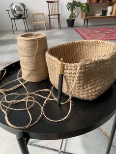 two baskets sitting on top of a black table next to twine and a pen