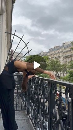 a woman is doing yoga on the balcony