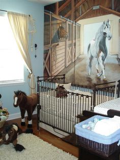 a baby's room decorated in blue and white with horses on the wall, crib bedding