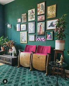 a living room with green walls and pictures on the wall