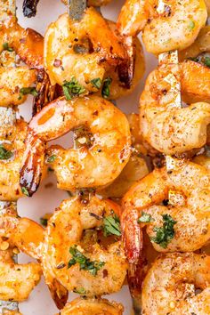 grilled shrimp with herbs and parsley on a white platter, ready to be served