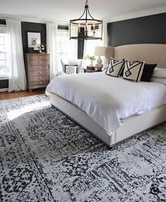 a bedroom with a bed, rug and chandelier