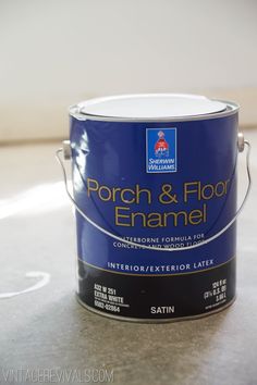 a blue paint can sitting on top of a countertop next to a white wall