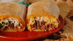 two burritos on a red plate with chips