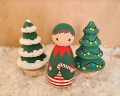 three christmas cupcakes with decorations on them sitting in the snow next to each other