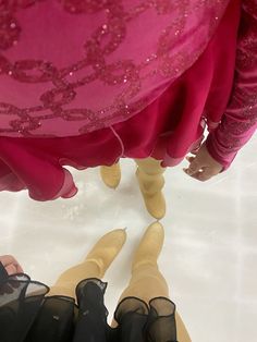 the legs of two women in black and pink dresses are seen from above as they stand next to each other