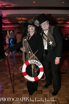 two people dressed in costumes standing on a dance floor