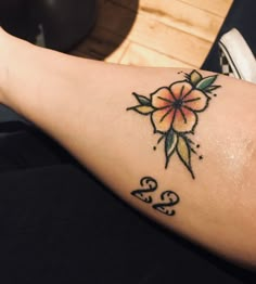 a woman's arm with a flower tattoo on the left side of her leg