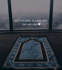 a blue rug sitting on top of a wooden floor next to a window with a quote written above it