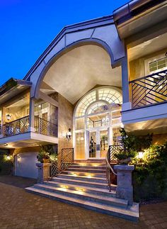 a large building with stairs leading up to the front door and entry way at night